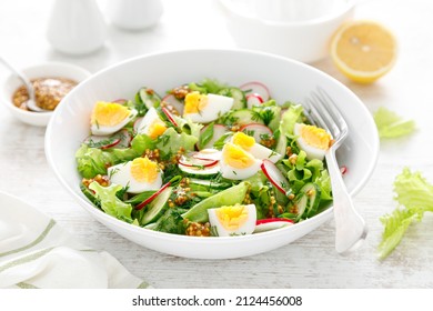 Easter Fresh Vegetable Salad With Boiled Egg, Radish And Cucumber, Dressing With Dijon Mustard And Lemon On White Wooden Table