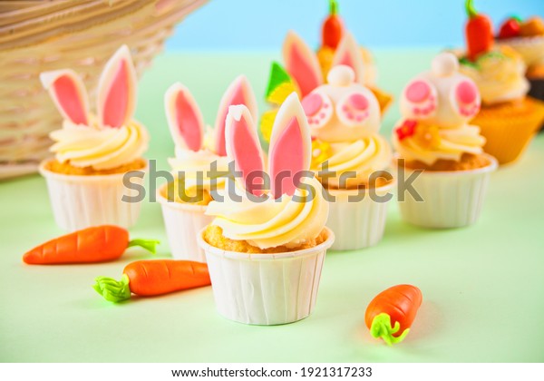 Easter funny bunny\
cupcakes. Easter celebration festive table. Basket of flowers\
tulips on the\
background.