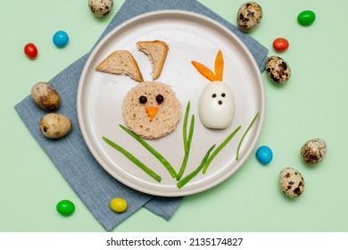 Easter Funny Creative Healthy Breakfast Lunch Food Idea For Kids, Children.Bunny, Rabbit Made From Boiled Chicken Eggs,bread, Peeled Carrots, Greens On Plate Green Table Background.Top View Flat Lay