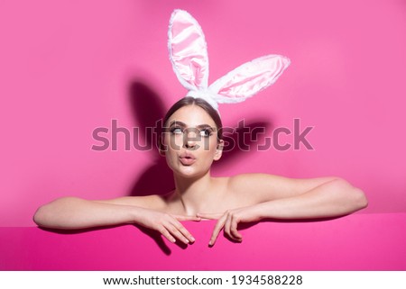 Easter funny woman with rabbit ears. Portrait of a pretty lovely girl isolated on pink banner, copy space. Blank poster banner