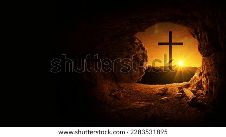 Easter and Good Friday concept, empty tomb with cross on mountain with amazing sunrise. Creative idea Easter. Religion and Christianity. Open empty cave with sunset view. Free copy space for design