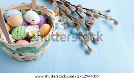 Easter greeting with painted egg in wicker basket and pussywillow branch arranged for elegant spring holiday celebration card design