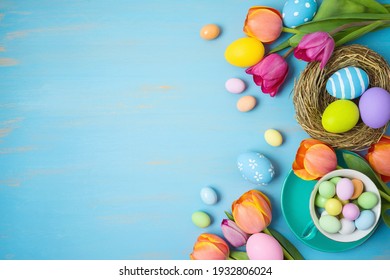 Easter holiday background with easter eggs and tulip flowers on wooden table - Powered by Shutterstock