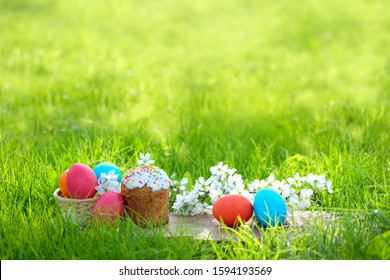 easter holiday. Easter cake, flowers and colorful painted eggs in green grass, natural background. beautiful rustic traditional scene. festive spring season. copy space