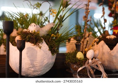 Easter holiday composition with broken egg with green moss and bouquet of red and white roses on the background of mirror with bokeh from garlands