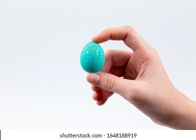  Concepto de vacaciones de Semana Santa. Manos femeninas coloreando huevos de codorniz de Pascua aislados en blanco.