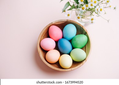 Easter holiday concept. Easter picture, multi-colored eggs in a wooden plate, on a pink background - Powered by Shutterstock