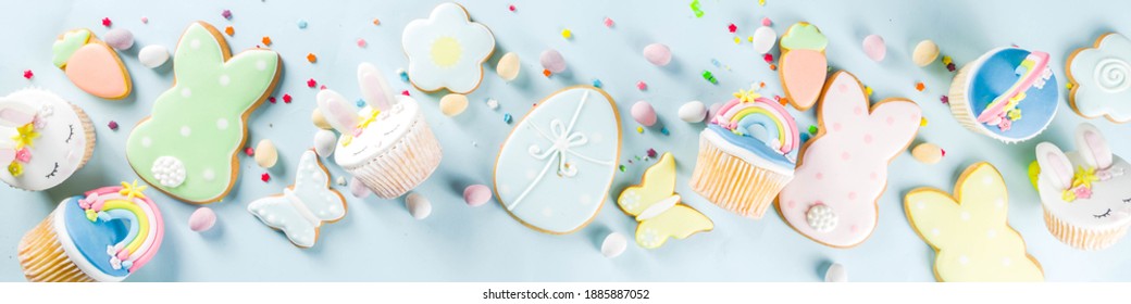Easter holiday greeting card background. Cute homemade cupcakes with traditional bunny, egg and springtime flowers decor.  Copy space for your text