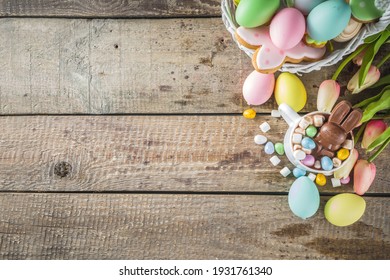 Easter hot chocolate with chocolate bunny rabbits. easter eggs and marshmallow, wooden background with spring flowers copy space