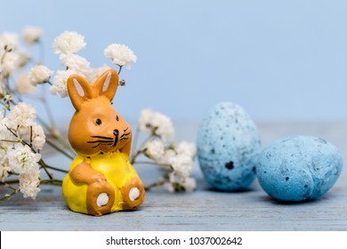 Easter image with easter bunny, blue easter eggs and white spring flower