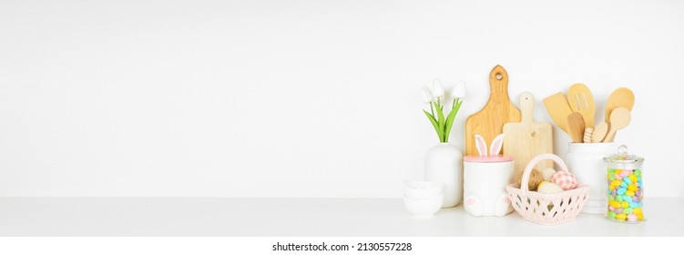 Easter Kitchenware, Utensils And Decor On A White Shelf Or Counter. Banner Against A White Wall Background With Copy Space. Spring Home Kitchen Cooking Concept.