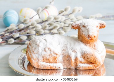 Easter lamb cake eggs and catkins on blue background