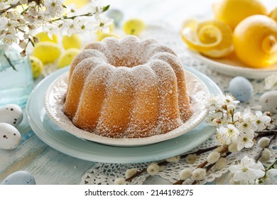 Easter lemon bundt cake, Babka sprinkled with powdered sugar on a festive table decorated with spring flowers, close up view