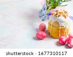 Easter pastries decorated with icing, candied fruit and nuts on a blue background. Spring easter composition with fresh flowers. Traditional pastries for the Orthodox holidays