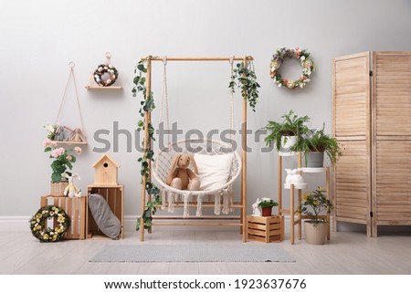Easter photo zone with floral decor and swing chair indoors