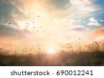 Easter Religious concept: Silhouette birds flying on meadow autumn sunrise landscape background