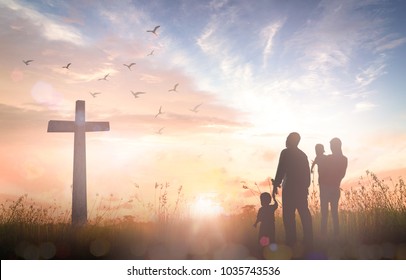 Easter Religious concept: Silhouette family looking for the cross of Jesus Christ on autumn sunrise background - Powered by Shutterstock