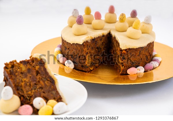 Easter Simnel Cake.\
Slice of Easter Cake, also known\
as Simnel cake with marzipan topping and eleven balls of marzipan\
representing the twelve apostles minus Judas. Mini chocolate Easter\
Eggs round th