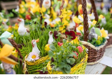 easter spring decoration goose with daisies and easter eggs in a wicker basket sold at an easter market, other decorations and golden rain in the background
 - Shutterstock ID 2262086757
