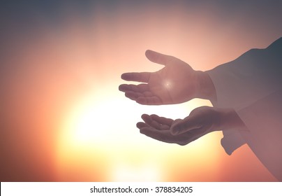 Easter Sunday concept: Silhouette scars in hands of Jesus Christ on sunrise background