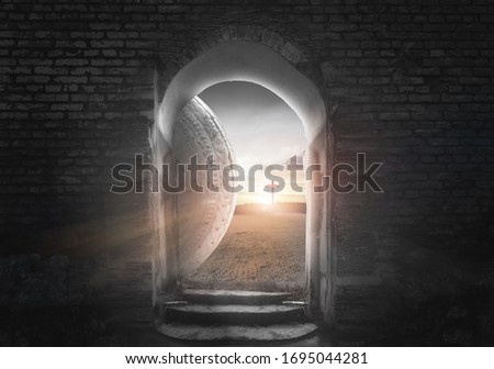 Easter Sunday concept: Tomb empty with cross on sunset background