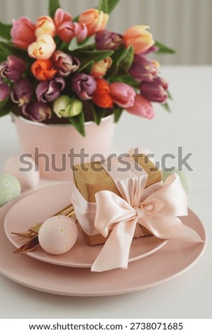 Easter Table Setting with Gift Box, Decorated Eggs and Tulips. Festive Spring Lifestyle