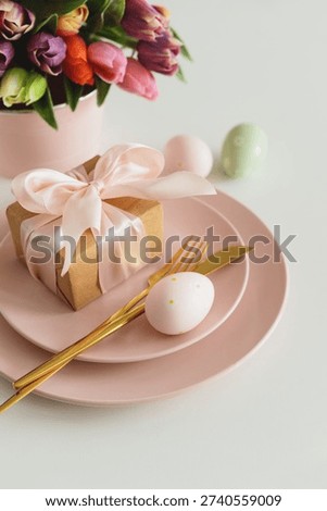 Easter Table Setting with Gift Box, Decorated Eggs and Tulips. Festive Spring Arrangement