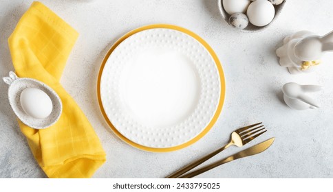 Easter table setting mock up. Festive elegant white with yellow table serving with eggs, white and yellow plates, golden cutlery, small bunnies on white. Restaurant menu template. Top view. Banner. - Powered by Shutterstock