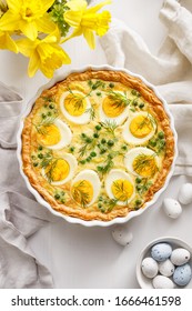 Easter Tart Quiche With Eggs And Green Peas In Casserole Dish On A White Table, Top View