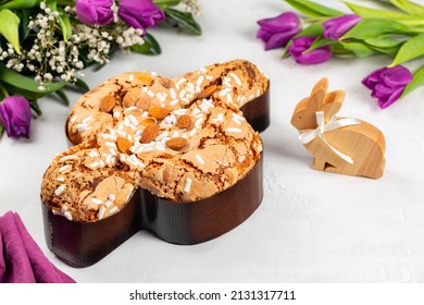 Easter tradition in Italy, Dove Cake topped with icing and almonds.  Colomba di Pasqua. Easter bunny. Spring flowers. Top view. - Shutterstock ID 2131317711