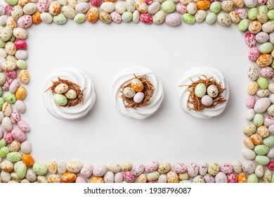 Easter Treat - White Meringues In Shape Of Nest With Multicolored Candy Chocolate Eggs. Overhead View, Flat Lay, Frame Composition. Festive Food Background. Holiday Symbol