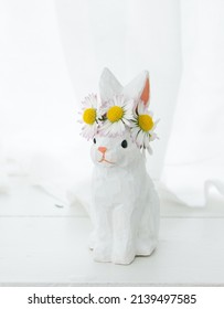 Easter wooden handmade rabbit with a wreath of daisies on his head