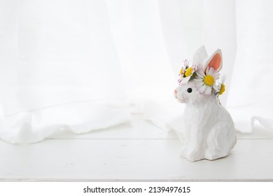 Easter wooden handmade rabbit with a wreath of daisies on his head