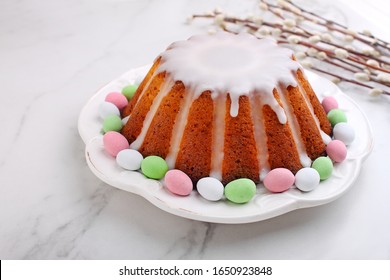 Easter Yeast Cake (Babka) On A White Plate On A Mardle Background. Traditional Easter Cake In Poland