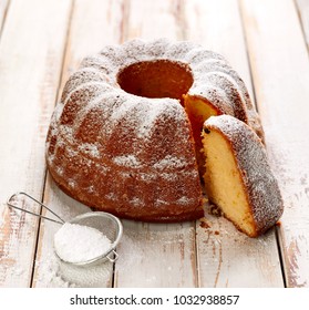 Easter Yeast Cake Sprinkled With Powdered Sugar On A Wooden White Table. Traditional Polish Easter Dessert