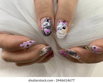 An Easter-inspired acrylic nails set featuring intricate designs of flowers and bunnies adorning a girl's hand, evoking the essence of springtime joy. - Powered by Shutterstock