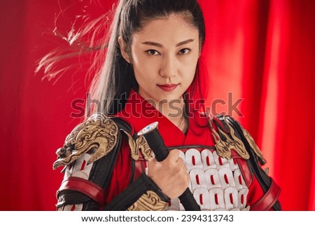 The Eastern beauty holds a long sword and is dressed in armor as the image of Mulan