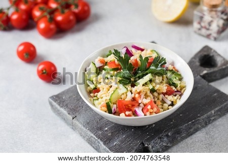 Eastern bulgur and vegetable tabbouleh salad in a plate. Vegetarian dish.