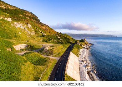 The Eastern Coast Of Northern Ireland And Antrim Coast Road, A.k.a. Giant's Causeway Coastal Route With Concrete Revetments. Aerial View At Sunrise.