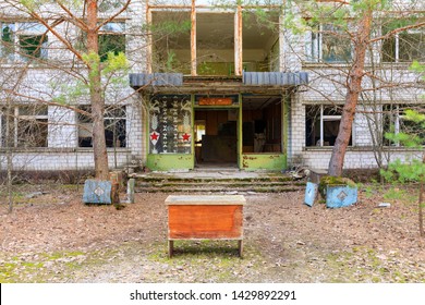 Eastern Europe, Ukraine, Pripyat, Chernobyl. Exterior Of Abandoned Police Station Office With A Desk Sitting Out Front.