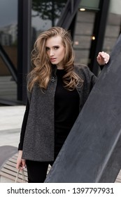 Eastern European Female Model With Curly Hair Posing For A Street Fashion Photo Shoot.