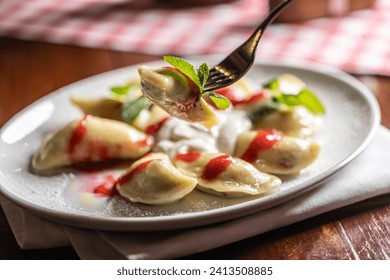 Eastern European traditional food dumplings - pierogi, varenyky, pirohy filled with strawberries and topped with jam.