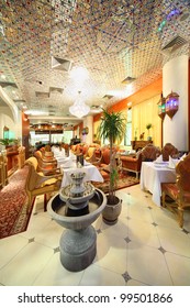 eastern interior of beautiful restaurant, potted palms and fountain