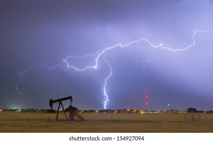 Eastern plains of the Rocky Mountain front range Weld County, Colorado, view of a pumpjack with a lightning thunderstorm strike near by.   - Powered by Shutterstock