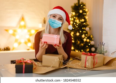 Easy To Buy With Online Shopping! Satisfied Young Woman With Medical Mask Holding Christmas Present, Looking At Camera.