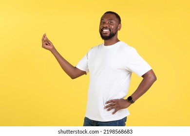 It's Easy. Cheerful African American Guy Clicking Fingers Smiling To Camera Standing Posing Over Yellow Background. Studio Shot Of Male Doing Finger Snap Gesture