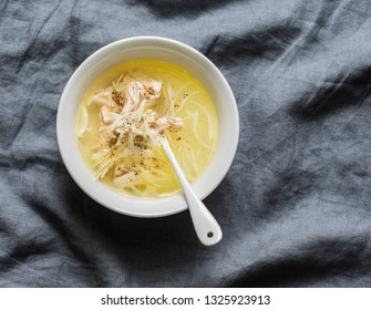 Easy chicken broth with chicken meat, onion and pepper. Soup base on a gray background, top view     