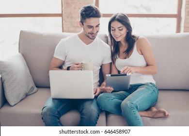 So Easy! Excited Beautiful Happy Couple Is Doing Online Shopping In Internet. They Are Indoors At Home On Cozy Couch In Casual Clothes, Relaxing And Buying Goods Easily