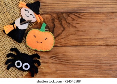 Easy Halloween crafts. Felt witch, pumpkin, spider ornaments on a wooden background with copy space for text. Cute Halloween handmade decor from felt. Sewing project for adults and kids. Top view - Powered by Shutterstock