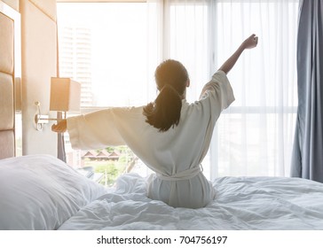 Easy lifestyle young Asian girl woman waking up in the morning taking a rest relaxing in hotel room for world lazy day concept
